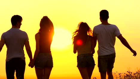 The-four-people-jumping-on-the-bright-sun-background.-slow-motion