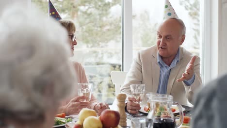 Senior-hombre-hablando-con-la-amiga-en-la-fiesta-de-cumpleaños