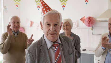 Portrait-of-Senior-Man-in-Partyhut-auf-Geburtstagsfeier