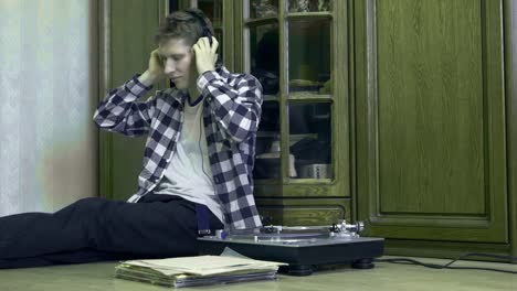 portrait-of-young-man-at-home-listening-to-the-vinyl-records,-relaxing-and-dreaning