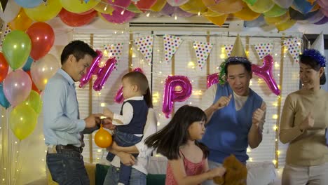 Group-of-young-asian-family-dancing-together-in-party-event-at-home.-Happy-family-celebrating-New-Year's-Eve.