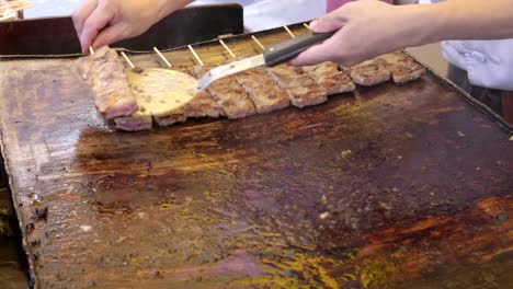 un-cocinero-mueve-pinchos-de-carne,-cocinar-en-una-parrilla