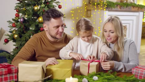 Niña-preparando-regalos-de-Navidad-con-los-padres