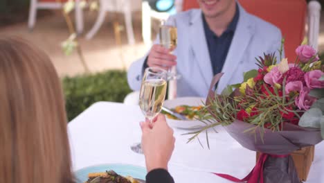 Couple-clinking-with-champagne-flutes-at-restaurant