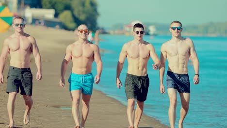 Portrait-of-beautiful-and-muscular-guys-walking-along-the-sandy-beach