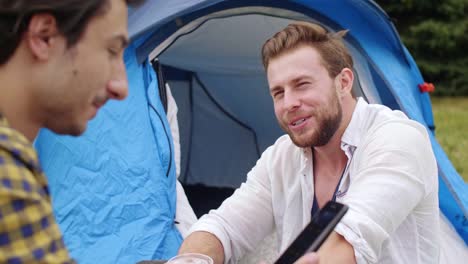 Freunde-sitzen-auf-dem-Rasen-beim-Musikfestival