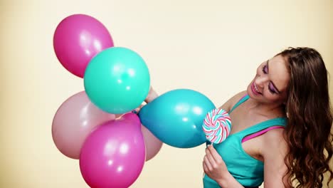 Niña-sonriente-mujer-con-globos-de-colores-y-paleta-4K