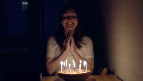 Mujer-joven-soplando-las-velas-en-la-torta-de-vacaciones