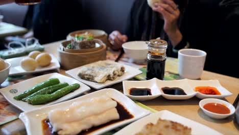 die-Hand-gießen-Gewürz-Saucen-für-Gruppe-während-Gourmet-Dim-Sum-Gerichte