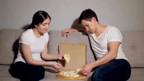 Beautiful-young-couple-in-casual-clothes-are-eating-pizza