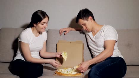 Hermosa-joven-pareja-en-ropa-casual-está-comiendo-pizza