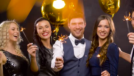 happy-friends-with-sparklers-at-christmas-party