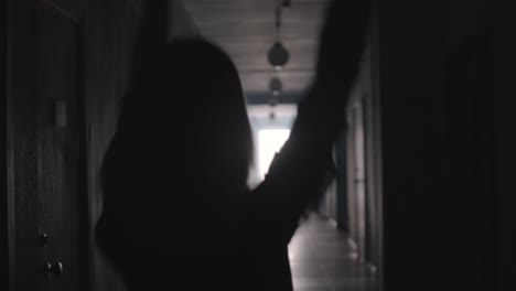 Silhouette-of-Joyful-Woman-Dancing-and-Walking-along-Hallway