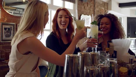 Female-Friends-Enjoying-Drink-In-Cocktail-Bar-Shot-On-R3D