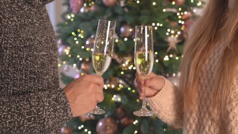 Male-and-female-hands-holds-goblet-bubbly-cheers