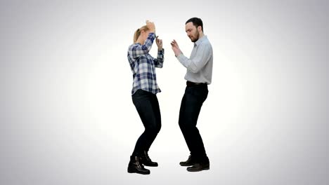 Young-couple-dancing-together-on-white-background