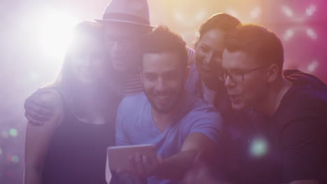 Group-of-Happy-Smiling-Friends-doing-Selfies-with-Mobile-Phone-on-Party.