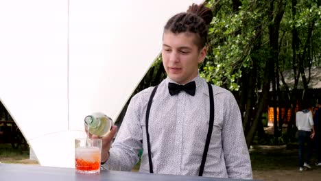 Barkeeper-macht-Mixgetränk-auf-Hintergrund-Natur-bar-Arbeiter-rom-in-Glas-mit-Eiswürfeln-aufgefüllt