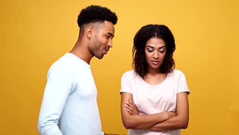 Seguro-joven-africano-tratar-a-una-mujer-bonita-hacia-fuera-una-fecha-aislada-sobre-fondo-amarillo