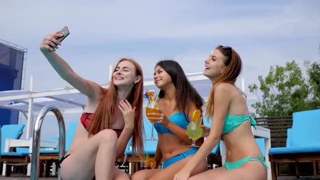 Selfie-of-girls-In-bathing-suit-With-cocktails-in-arms-in-Poolside,-Young-women-Record-video-on-gadget