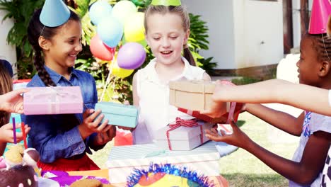 Sonriente-niña-recibir-regalos-de-amigos-4k