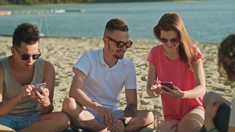 Junge-Leute,-die-Spaß-am-Strand-mit-Handys