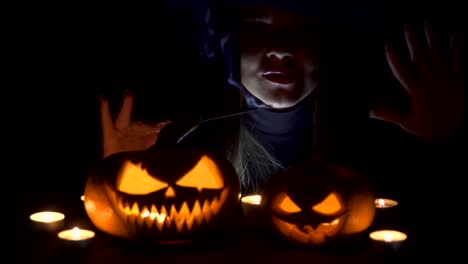 Halloween-Witch-with-a-magic-Pumpkin.-Beautiful-young-woman-in-witches-hat-and-costume-holding-carved-pumpkin.-Halloween-art-design