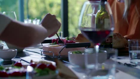 People-eating.Four-caucasian-friends-man-and-woman-mediterranean-italian-salad,meat-steak-and-bread-lunch-or-dinner.-Summer-party-at-home-in-modern-house-4k-handheld-video