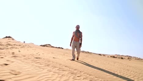 Young-man-with-steampunk-goggles-walking-alone-in-desert