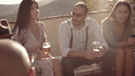 Elegant-multi-ethnic-friends-having-fun-and-drinking-wine-and-beer