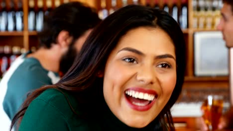 Woman-having-mug-of-beer-while-interacting-with-friends-4k