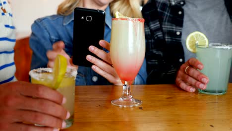 Friends-using-mobile-phone-while-having-drink-4k