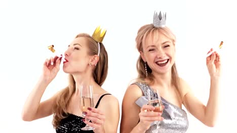 2-beautiful-cheerful-twin-girls-with-glasses-of-champagne-dancing-in-the-studio-on-a-white-background---closeup