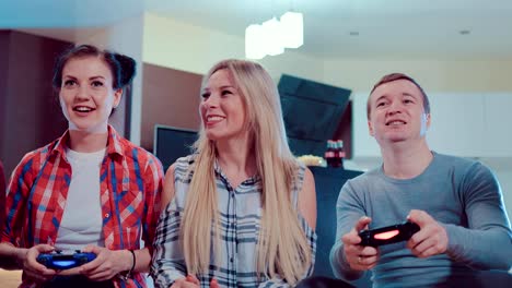 Glückliche-Gruppe-des-Lachens-männliche-und-weibliche-Freunde-spielen-von-Videospielen-mit-wireless-Controller