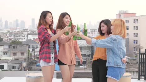 A-group-of-Asian-woman-are-drinking-beer-and-dancing-happily-on-the-rooftop.