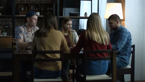 Group-of-happy-friends-playing-board-game-at-table