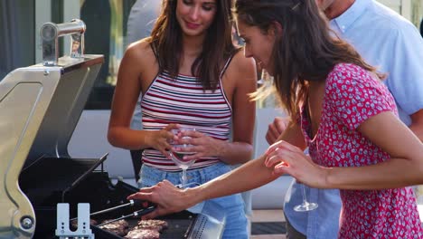 Gruppe-von-Freunden-Grillen-zu-Hause-gemeinsam-genießen