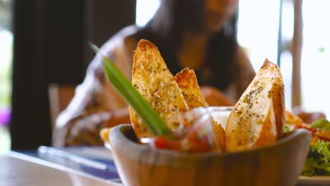 Schuss-von-einem-Teller-mit-Brot-Brote-hautnah,-während-asiatische-Frau-nehmen,-Essen-im-Restaurant.-Gesunde-Ernährung-und-Diät-Konzept.