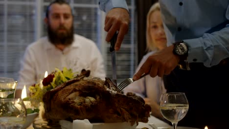 Man-carving-turkey-on-holiday-dinner