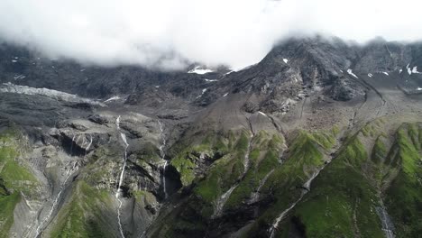 Drone-volando-hacia-atrás-en-el-fusión-glaciar-de-montaña