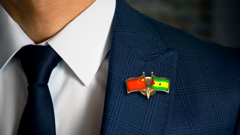 Geschäftsmann-zu-Fuß-in-Richtung-Kamera-mit-Freund-Land-Flaggen-Pin-China---Sao-Tome-und-Principe