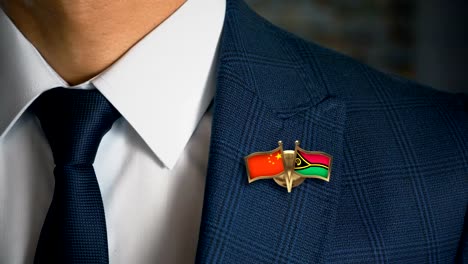 Businessman-Walking-Towards-Camera-With-Friend-Country-Flags-Pin-China---Vanuatu