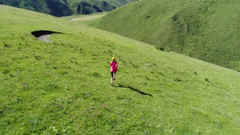 Aerial-view-of-young-fitness-woman-trail-runner-running-on-top-of--grassland-mountain.4k