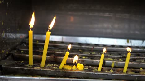 Ardiente-luz-de-la-vela-frente-a-concepto-de-templo-asiático---fe,-espiritualidad-y-religión