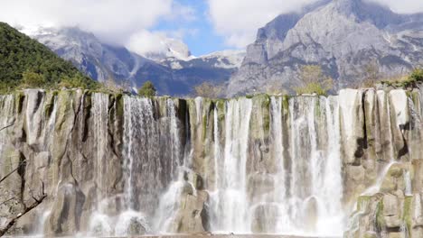 Cascada-blanca-en-el-río-Baishui-y-Jade-Dragon-Snow-Mountain,-Lijiang,-Yunnan,-China.