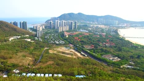 Pequeñas-casas-y-rascacielos-entre-la-vista-aérea-de-las-montañas