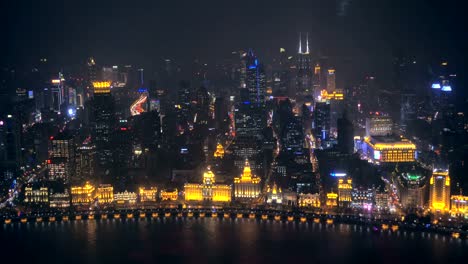 Embarcaciones-fluviales-sobre-el-río-Huangpu-y-como-fondo-el-horizonte-de-la-parte-norte-de-Puxi,-en-la-noche.