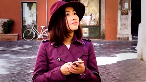 young-asian-woman's-profile-using--smartphone,city-background