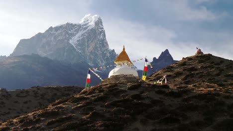 Steadicam-shot-of-stupa-with-prayer-flags-on-track-to-the-base-camp-of-Everest-in-the-Himalayas,-Nepal