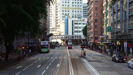 Historic-double-decker-city-tram-bus-approaching-on-downtown-city-street-in-Hong-Kong,-China-in-Asia